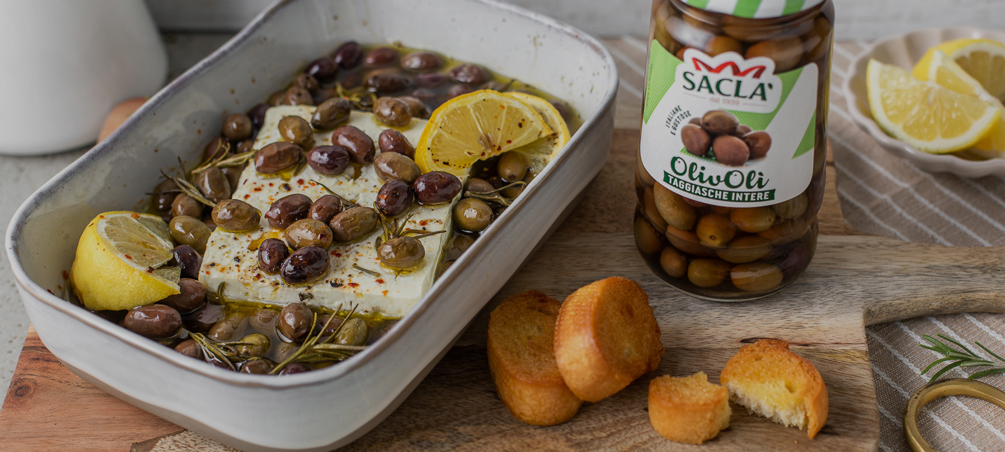 Feta al forno con Olive Taggiasche Intere, limone, rosmarino e pane all’aglio