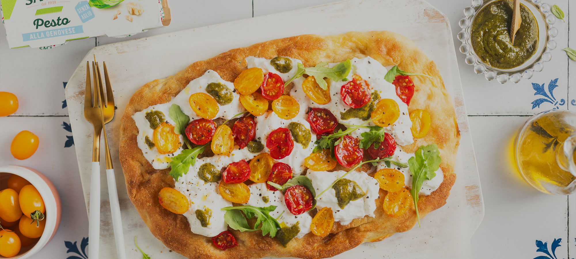 Pinsa romana con pomodorini gialli e rossi, burrata e pesto senz’aglio