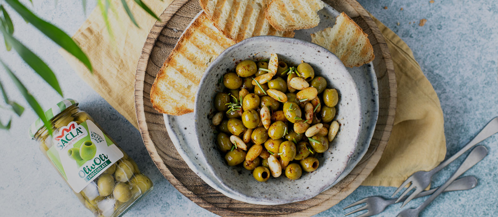 Olive Verdi Snocciolate e mandorle marinate alla paprika affumicata con crostini tostati all’aglio